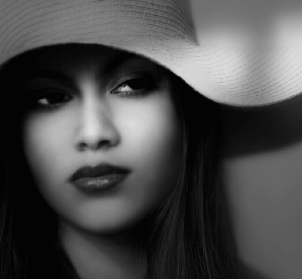 Black-and-white close-up portrait of a woman in a wide-brimmed hat