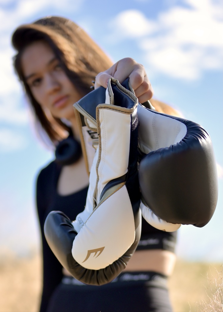 Boxer portrait holding red gloves in warm outdoor light